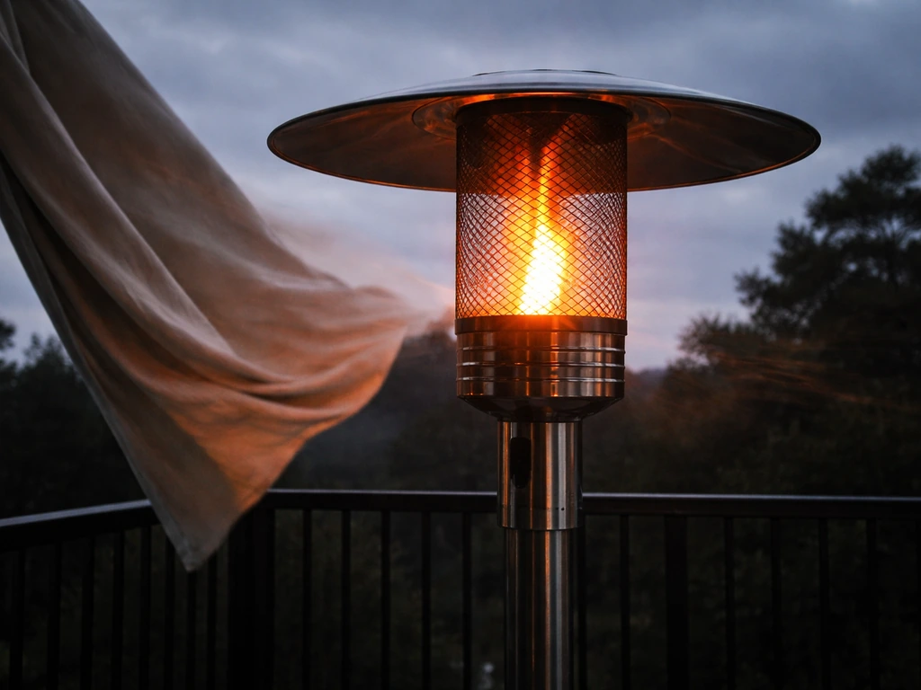 Windy outdoor patio with a lit combustion heater and visible flame and airflow.